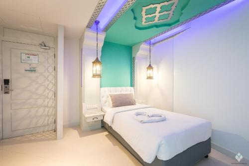 a bedroom with a white bed with a blue ceiling at The Verandah - SHA Extra Plus in Ao Nang Beach