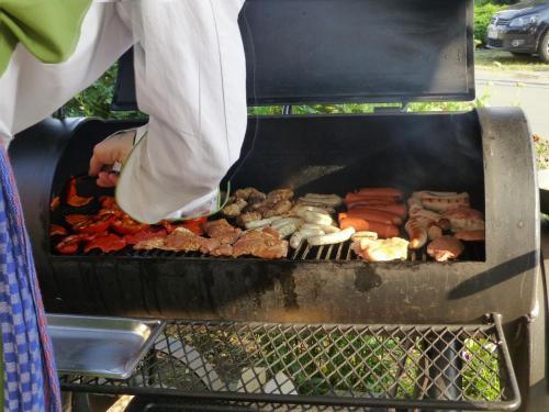 a person cooking meat and vegetables on a grill at Waldesblick, Hotel-Restaurant in Lahr