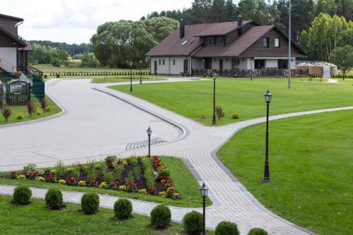 a park with a house and a garden with flowers at Sodyba Ignė in Druskininkai