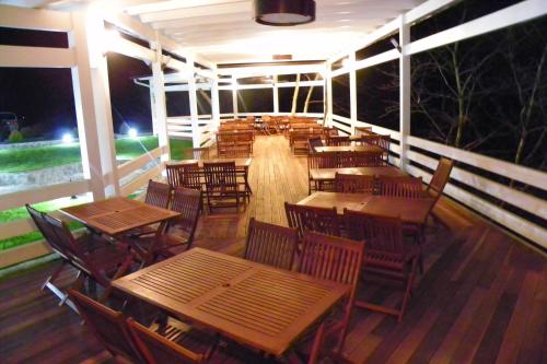 ein leeres Restaurant mit Holztischen und -stühlen in der Nacht in der Unterkunft Hotel Marub in Rubik