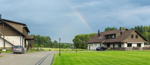 a house with a car parked next to a street at Sodyba Ignė in Druskininkai
