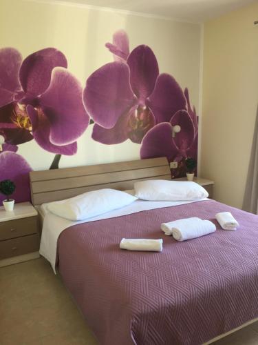 a bedroom with a purple bed with two towels on it at Apartments Villa Katija in Drvenik