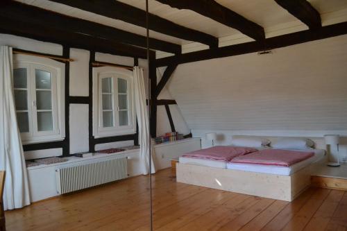 a bedroom with a bed and two windows at Ferienidyll Cleebourg in Cleebourg