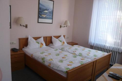 a bedroom with a large bed with a white comforter at Landgasthof Schützenhof Artlenburg in Artlenburg