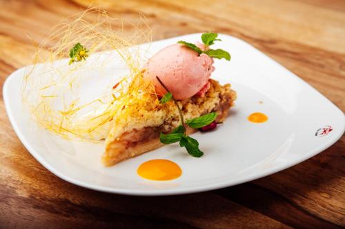 a white plate with a piece of food on a table at Four Winds in Krynica Morska