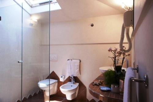 uma casa de banho com um WC e uma cabina de duche em vidro. em Hotel Derby em Bellaria-Igea Marina