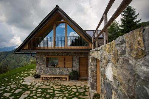 a house on a hill with a stone wall at Eco Chalet AstraMONTANA in Tolmin