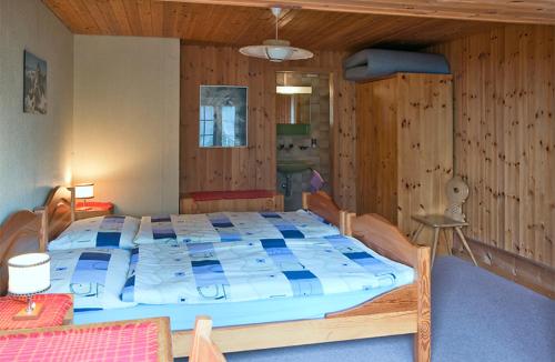 Cama grande en habitación con paredes de madera en Chemihütte en Aeschi