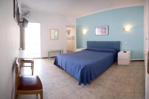 a bedroom with a blue bed and a chair at L´Hostalet in Tossa de Mar