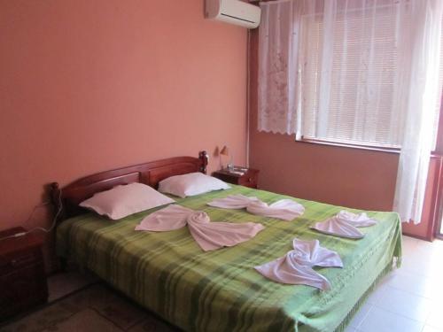 Un dormitorio con una cama verde con toallas. en House Sofia, en Sveti Vlas