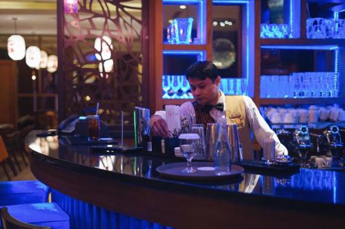 a man standing behind a bar in a restaurant at Sotis Residence Pejompongan in Jakarta