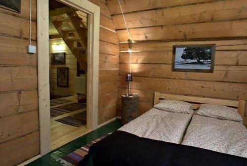 a bedroom with a bed in a log cabin at Legenda Tatr in Zakopane