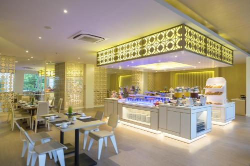 a restaurant with tables and chairs and a counter at Grand Mirage Resort & Thalasso Bali in Nusa Dua