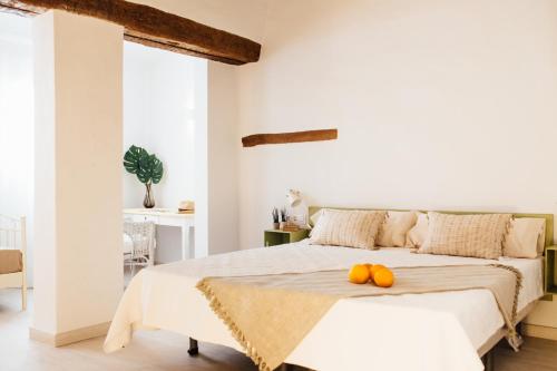 a white bedroom with a bed with two pumpkins on it at OttoH Charm Stay in Valencia
