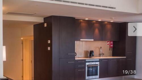 a kitchen with dark brown cabinets and a stove at Troia Resort Apt Marina in Troia