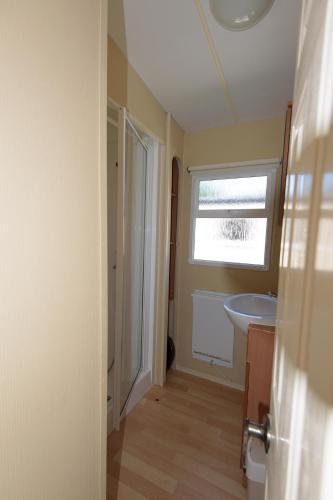 a bathroom with a sink and a window at Holiday Lodge in Pogorzelica