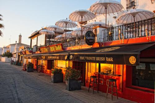 a building with umbrellas on top of it on a street at Hotel Playa de Regla in Chipiona