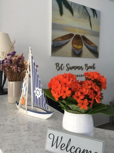 a table with a vase of flowers and a welcome sign at BC Summer Beach in Pran Buri