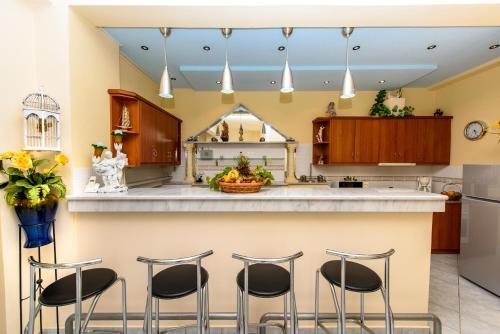 a kitchen with a large island with four stools at Christianna House -Villa in Georgioupolis