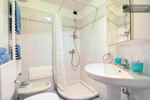 a white bathroom with a toilet and a sink at Casa Vacanze Oneglia in Imperia