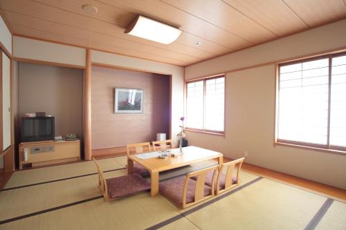 um quarto com uma mesa e cadeiras e uma televisão em Cent Core Yamaguchi em Yamaguchi