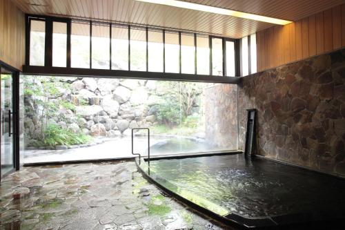 uma piscina de água num quarto com janela em Cent Core Yamaguchi em Yamaguchi