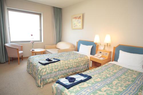 Habitación de hotel con 2 camas y ventana en Cent Core Yamaguchi en Yamaguchi