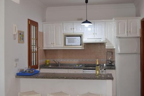 eine Küche mit weißen Schränken und einem weißen Kühlschrank in der Unterkunft Villas Don Rafael in Puerto del Carmen