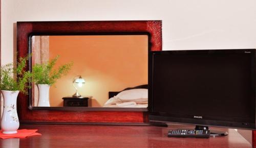 un monitor de ordenador en un escritorio frente a un espejo en Camves Inn, en Sighetu Marmaţiei