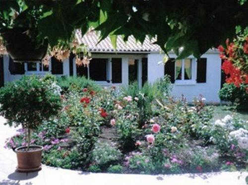 a garden with flowers in front of a house at Chambres d'Hôtes La Forterie in Vairé