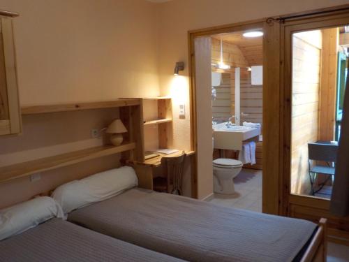 ein Schlafzimmer mit einem Bett und ein Badezimmer mit einem Waschbecken in der Unterkunft Hôtel Engilberge in Ailefroide