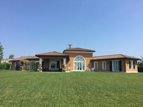 dom z dużym trawnikiem przed nim w obiekcie Front Row Golf Villa Bogogno w mieście Bogogno