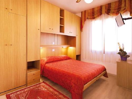 sypialnia z czerwonym łóżkiem i oknem w obiekcie Locanda da Scarpa w Cavallino-Treporti