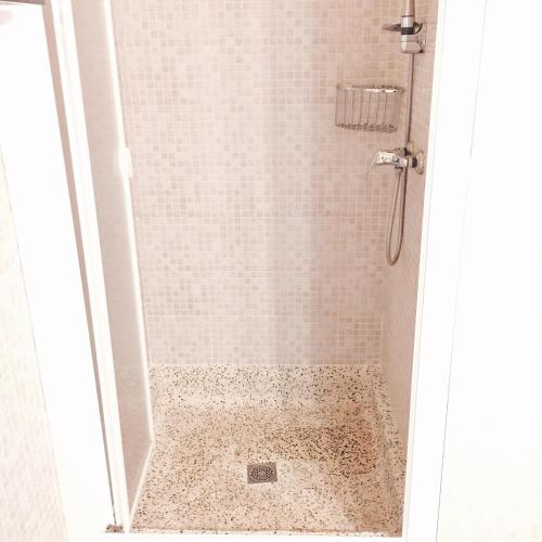 a bathroom with a shower with a tiled floor at Apartament Carme in Llança