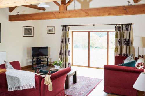a living room with a large sliding glass door at Dallow Hall Barns in Grantley