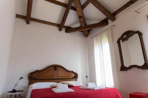 a bedroom with a red bed with two towels on it at Appartamento Cà del Bianco 4 in Venice