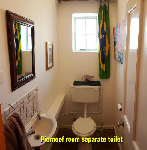 a bathroom with a toilet and a sink and a tub at Purple House B&B Smithfield in Smithfield