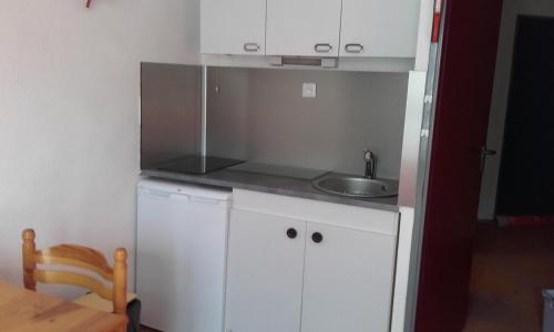 Elle comprend une petite cuisine avec des placards blancs et un évier. dans l'établissement Studio Sainte Marie De Campan, à Sainte-Marie-de-Campan