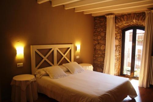 een slaapkamer met een groot bed en een raam bij El Castell de la Pobla de Lillet (Adults Only) in La Pobla de Lillet