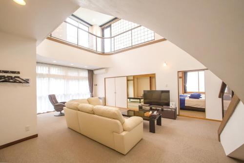 a living room with a couch and a tv at Condominium Panoramique Motomachi in Hakodate