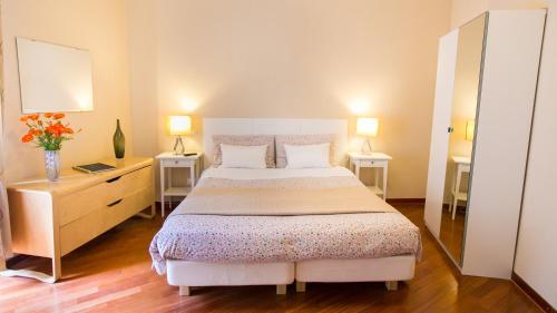 a bedroom with a large bed with two tables and two lamps at Hotel Martino Ai Monti in Rome