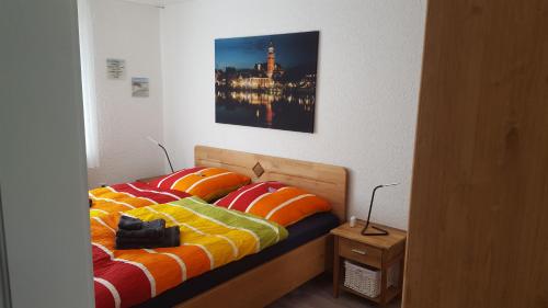 a bedroom with a bed with a picture on the wall at Ferienwohnung Leer in Leer