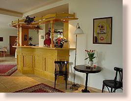 a woman standing at a bar in a room with a table at Hotel Garni Burgstemmer Hof in Burgstemmen