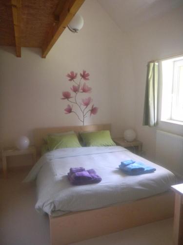 een slaapkamer met een bed met paarse handdoeken erop bij Verreveld in Londerzeel