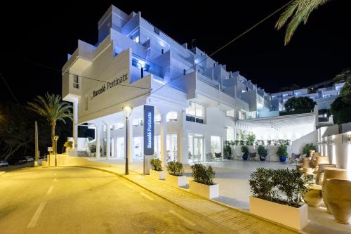 a large white building with lights on it at night at Barceló Portinatx - Adults Only in Portinatx