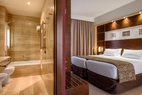 um quarto de hotel com uma cama e uma casa de banho em Exe León em León