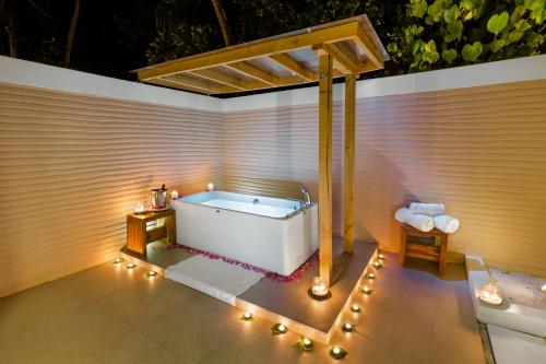 a bathroom with a tub with lights around it at Kudafushi Resort & Spa in Raa Atoll