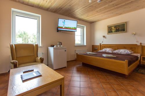 a bedroom with a bed and a tv on the wall at Sodyba Ignė in Druskininkai