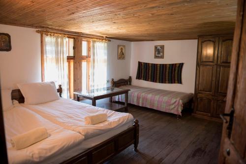 a bedroom with two beds and a table in it at Екокомплекс Катунище in Katunishte