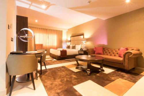a living room with a couch and a bed at The Palms by Eagles in Takoradi